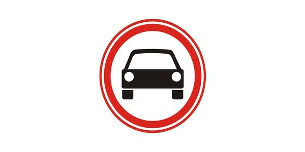 Image: red-edged white circle with a front-facing black passenger car and two pale headlights.